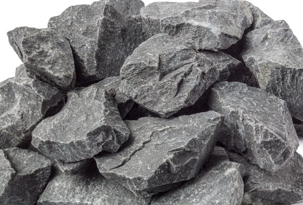 Gros plan sur un amas de pierres gris foncé à texture rugueuse, fond blanc.